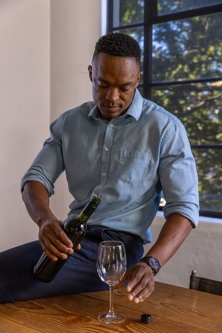 Man Pouring Red Wine in Cozy Home Setting