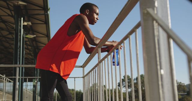 Athlete Resting on Track Field Rail During Training - Download Free Stock Images Pikwizard.com