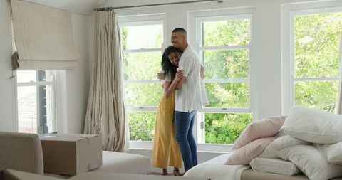 Diverse Couple Embracing in Sunlit Home During Move-In Day