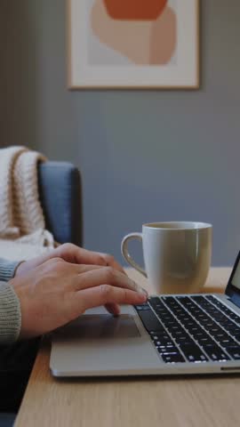 Typing Hands on Backlit Laptop Keyboard at Home Desk with Coffee Mug — Vertical Video Clip