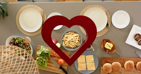 Romantic burger assembly flatlay with heart overlay, fries, buns, cheese, fresh lettuce
