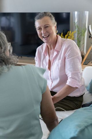 Senior mother and daughter relaxing in cozy living room setting