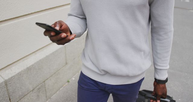 Man Holding Smartphone and Rolled Up Umbrella Outdoors - Download Free Stock Images Pikwizard.com