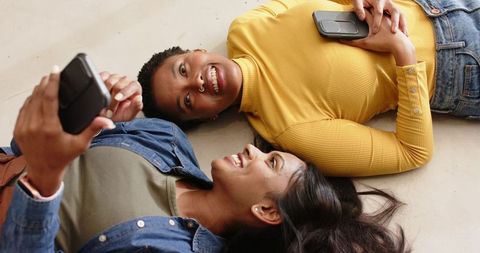 Diverse friends bonding through smartphones indoors