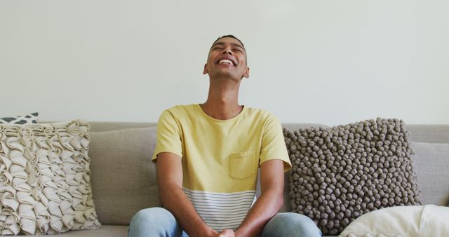 Happy Young Man Laughing on Comfortable Couch at Home - Download Free Stock Images Pikwizard.com