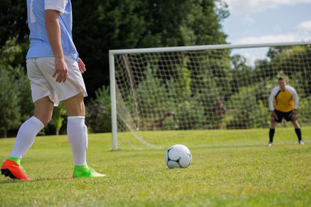Soccer player is ready to kick ball from penalty spot in the ground