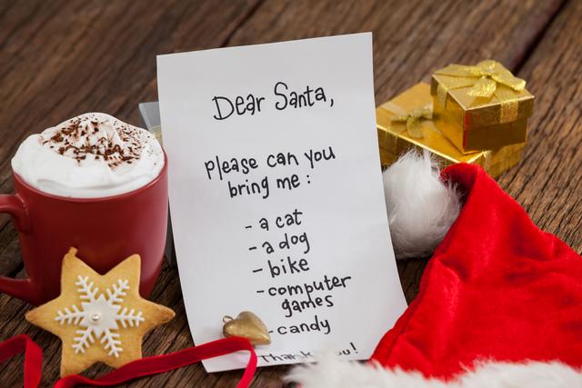 This image captures a festive holiday scene with a letter to Santa Claus, a cup of hot chocolate, gifts, and a Santa hat on a wooden background. Ideal for use in holiday greeting cards, Christmas advertisements, festive blog posts, and social media content celebrating the holiday season.
