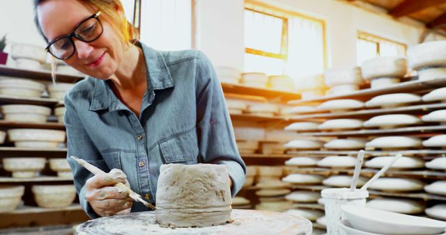 Female Artist Sculpting Clay Pot in Sunlit Pottery Studio - Download Free Stock Images Pikwizard.com