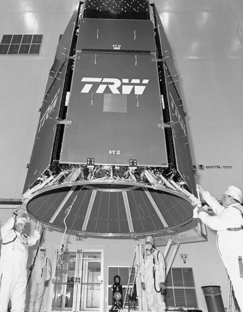 S89-28093 (29 Dec 1988) --- In the clean room of the vertical processing facility, the  TDRS-D satellite is hoisted, thus beginning the mating process with the inertial upper stage (IUS), located in an adjacent test cell.