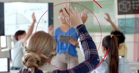 Student raising hand in tech classroom with teacher holding tablet and data overlay