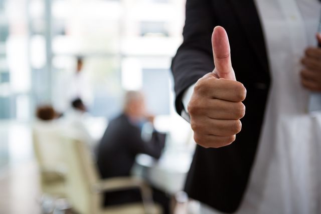 Businesswoman giving thumbs up in office, indicating success and approval. Ideal for business, corporate, and motivational themes. Can be used in presentations, websites, and marketing materials to convey positivity and confidence.
