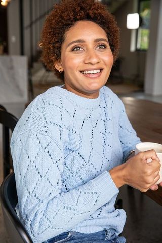 Joyful Woman Relaxing with Coffee in Cozy Café Environment