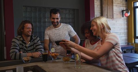 Happy Friends Socializing with Drinks and Smartphone at Bar - Download Free Stock Images Pikwizard.com