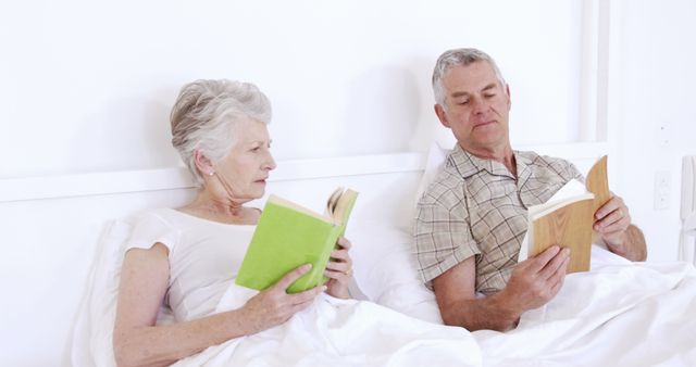 Senior couple reading book in bed - Download Free Stock Photos Pikwizard.com