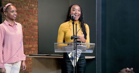 Confident woman presenting business ideas at podium