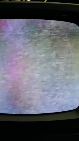 Vertical video showing curved monitor flickering multicolor static gradient in retro bezel