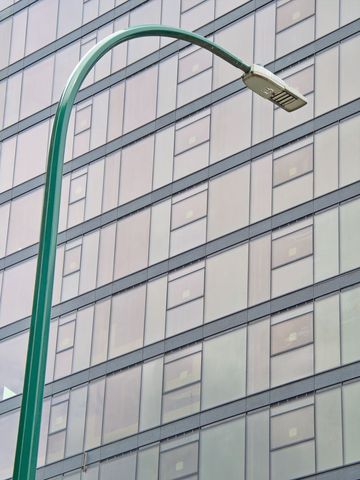 Modern technology streetlight against skyscraper glass facade