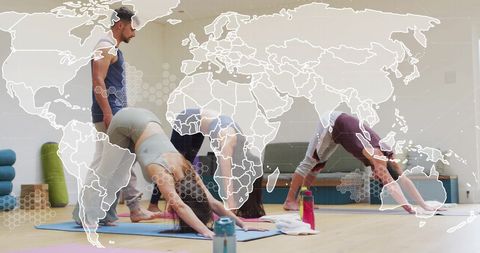 Yoga class showcasing a diverse group interacting with a futuristic digital map overlay and data processing interface. Useful for promoting fitness, technology integration in health, global communication in wellness communities, and digital transformation in healthy lifestyles.