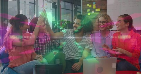 Creative coworkers with digital neon lights in modern office