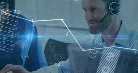 Businessman using headset and computer with financial data overlay