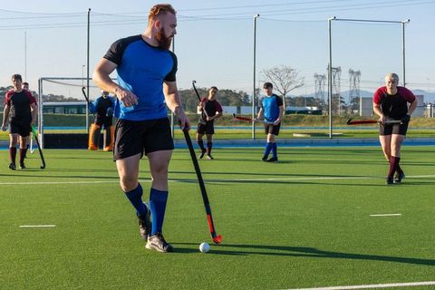 Field Hockey Player Dribbling Ball on Turf During Match