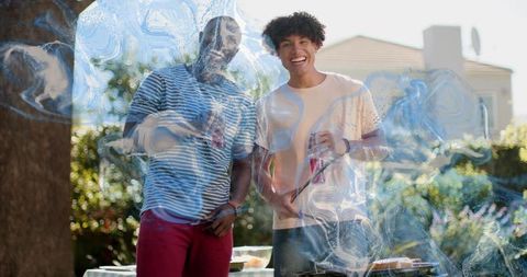 Friends Grilling and Laughing in Sunny Backyard Holding Drinks and Tongs