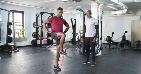 Two Men Exercising with Resistance Band in Gym