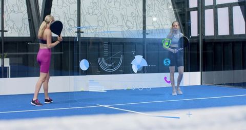 Female padel players training on blue court using augmented reality hud and analytics