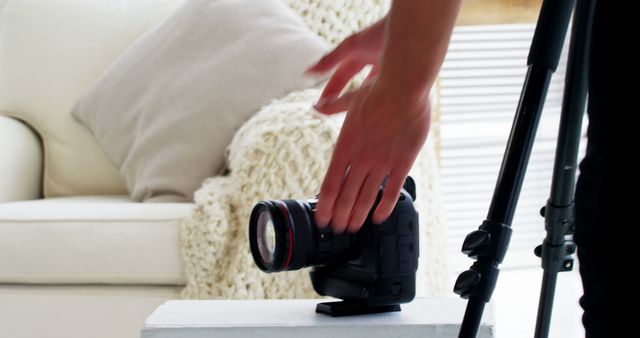 Close-Up of Photographer Adjusting Camera on Tripod in Cozy Living Room - Download Free Stock Images Pikwizard.com