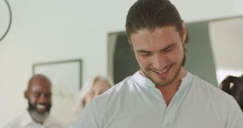 Man Smiling Joyfully at Social Event with Family and Friends