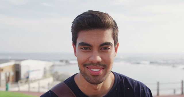 Smiling Young Man Outdoors with Ocean View Background - Download Free Stock Images Pikwizard.com