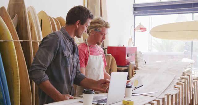 Two Men Working in Surfboard Workshop with Laptops - Download Free Stock Images Pikwizard.com