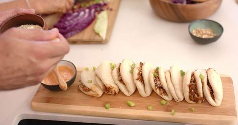 Sprinkling Sesame Seeds on Freshly Made Bao Buns