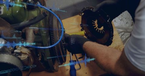 Gloved mechanic tightening flywheel bolts while holding clutch with digital diagnostic overlay