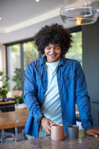 African American Man Enjoying Coffee in Modern Kitchen Interior