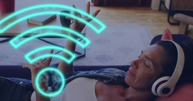 Composite of wifi icons data processing over biracial woman in headphones on sofa. Global connections, computing and data processing concept digitally generated image.