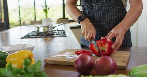 Pregnant Woman Preparing Fresh Red Peppers in Modern Kitchen
