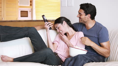 Couple Enjoying Movie Night at Home with Snacks