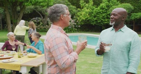 Middle-Aged Friends Enjoying Backyard Luncheon Near Pool