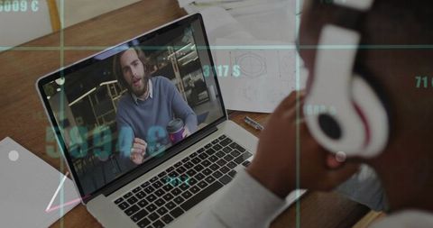 Remote team collaborating via video call with laptop speaker and headset in workspace