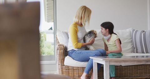 Mother and Daughter Relaxing with Dog on Sofa