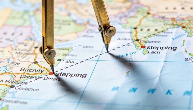 Measuring sea distance with brass compasses on vintage map for navigation planning
