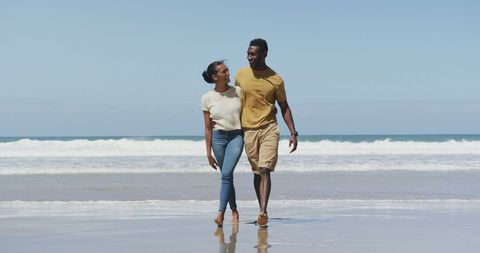 Happy Couple Walking on Scenic Beach Embracing Outdoors