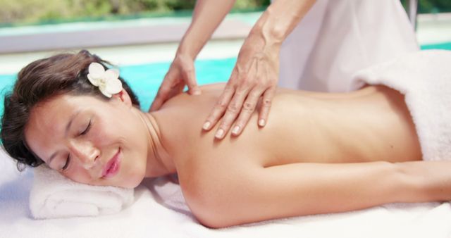 Attractive brunette having massage poolside - Download Free Stock Photos Pikwizard.com