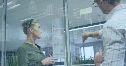 Business Professionals Analyzing Data on Transparent Board