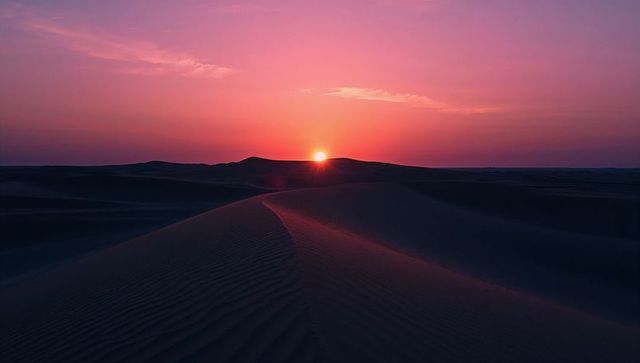 Mesmerizing Desert Sunset with Silhouetted Sand Dunes