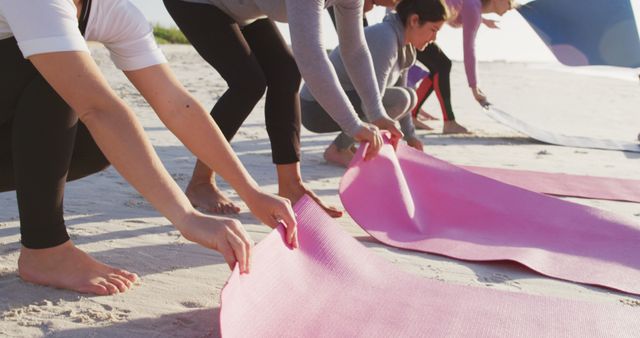 Group Practicing Yoga on Beach Unfolding Mats at Sunrise - Download Free Stock Images Pikwizard.com