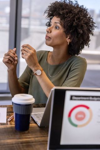 Businesswoman Discussing Financial Strategy at Office Desk