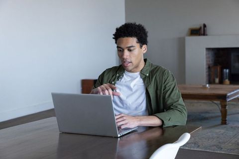 Focused man working on laptop in cozy home setting