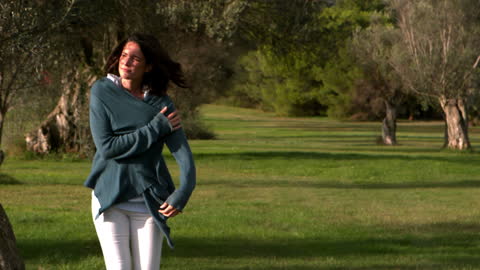 Woman Strolling in Park on Windy Day Embracing Nature
